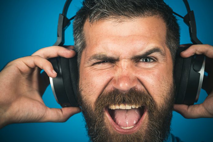 Emotional Man With Headphones Listening Music. Closeup Portrait.