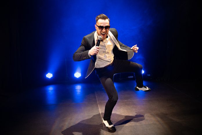 Handsome Presenter And Showman In A Stylish Suit With A Micropho