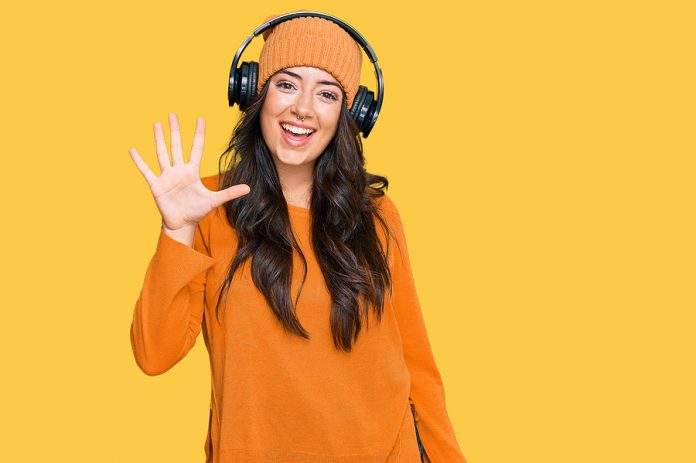 Beautiful brunette young woman listening to music using headphon