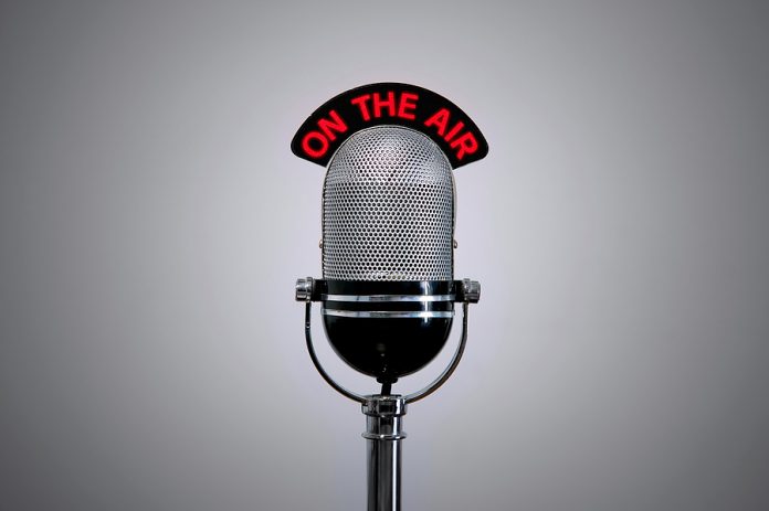 Old retro microphone with illuminated 'On the Air' sign.