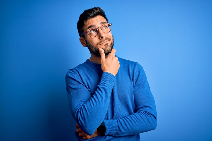 Young handsome man with beard wearing casual sweater and glasses
