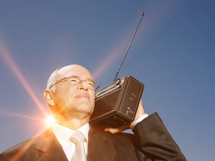 Senior business man using vintage radio