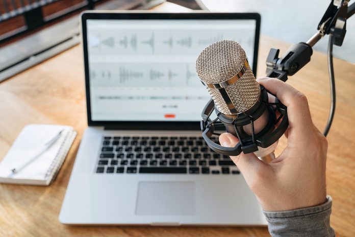 Close-up Of Man's Hand Holding Microphone In Broadcasting Studi