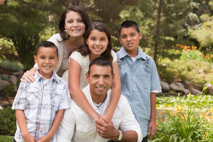 Happy Hispanic Family In The Park