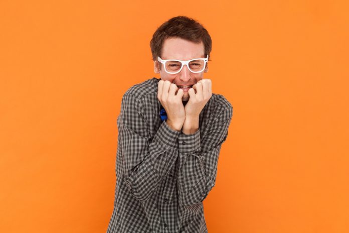 Anxious Puzzled Man Nerd Bites Finger Nails Stands Insecure And