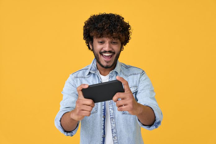 Excited Happy Young Indian Man Gamer Player Using Smartphone Pla