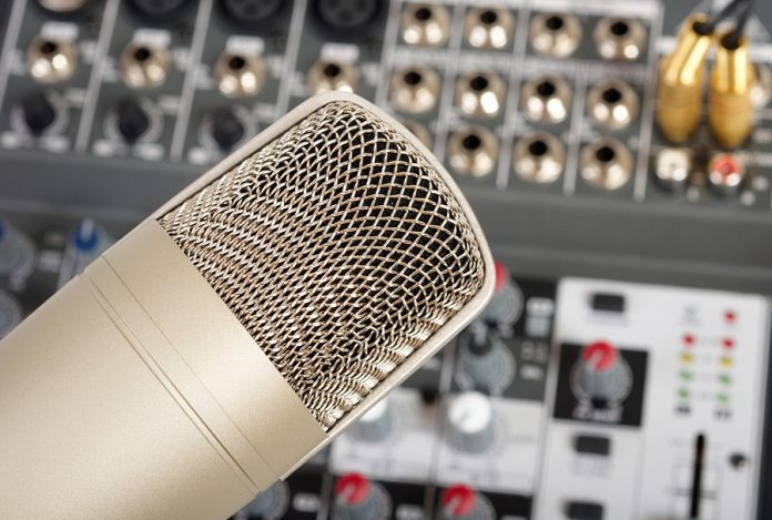 Studio microphone on the audio control console background