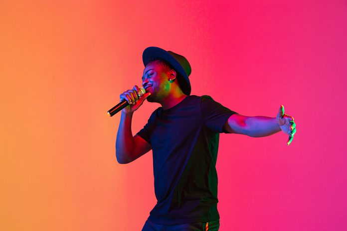 Young African-american Musician Singing On Gradient Orange-purpl