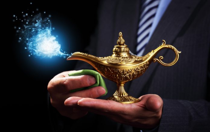 Businessman holding and rubbing a magic Aladdins genie lamp conc