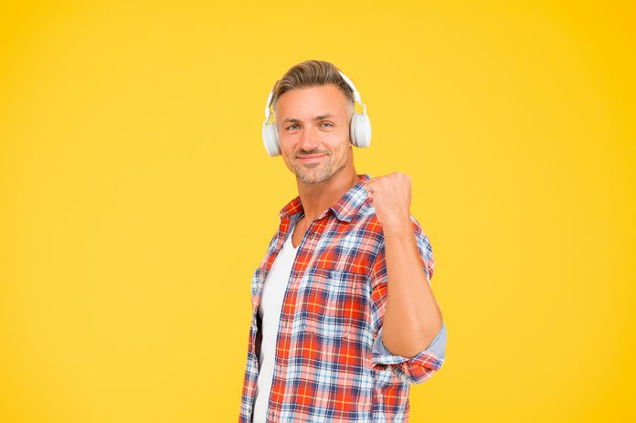 Happy Man Clench Fist Listening To Music Playing In Modern Earph
